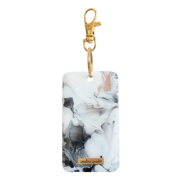 Llavero rectangular pintado a mano por Ana Tere Canales. Un diseño inspirado en la elegancia del mármol con colores blanco, negro y rose gold.