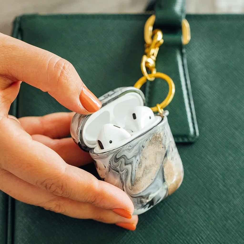 Funda para proteger AirPods, pintada a mano por Ana Tere Canales. Un diseño inspirado en la elegancia del mármol con colores blanco, negro y rose gold.