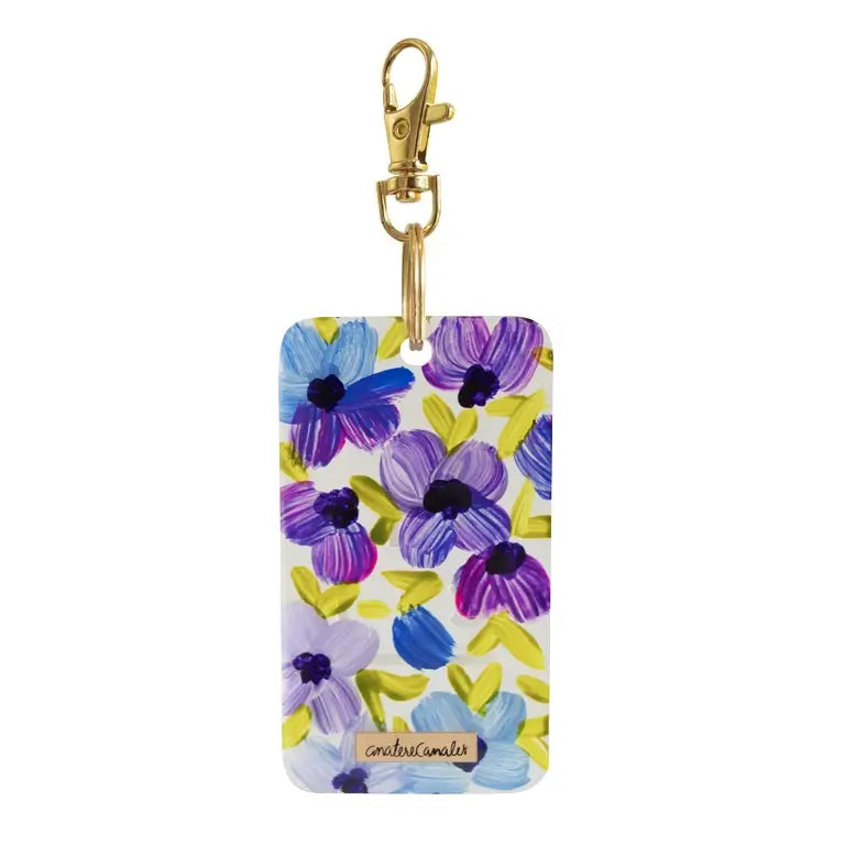 Llavero rectangular pintado a mano por Ana Tere Canales. Un diseño de flores en morados y verdes.