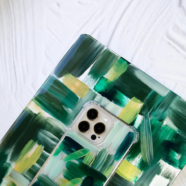 Fundas para proteger iPhone y MacBook, pintadas a mano por Ana Tere Canales. Un diseño en tonos verdes con toques dorados.