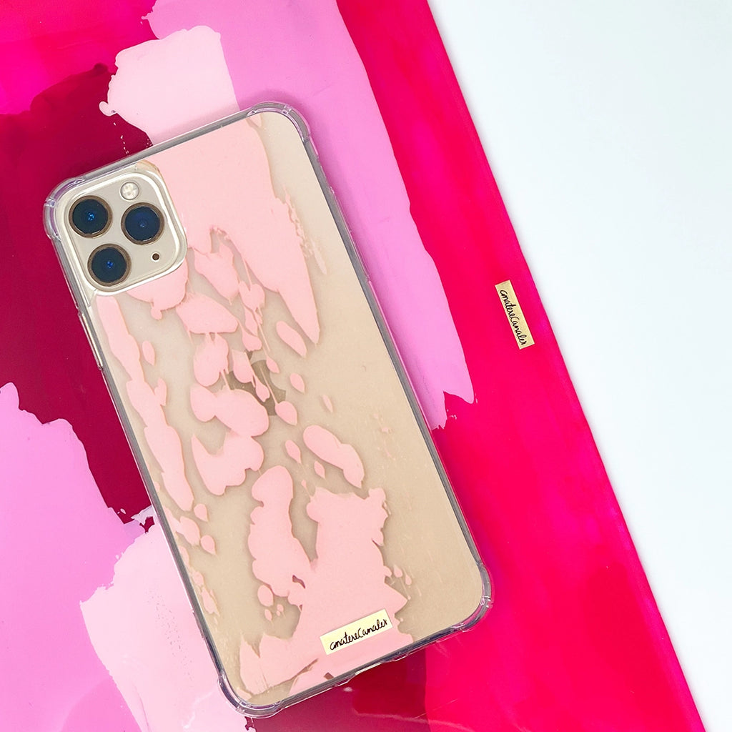 Fundas para iPhone y MacBook pintadas a mano por Ana Tere Canales. Diseños artístico en tonos rosa suaves y estilo contemporáneo.