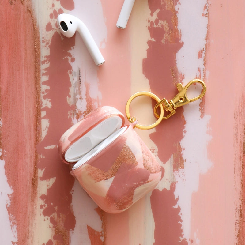 Funda para AirPods Cinnamon Signature Strokes con pinceladas artísticas en tonos cálidos inspiradas en crecimiento, viajes y libertad. Pintada por Ana Tere Canales.