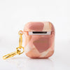 Funda para AirPods Cinnamon Signature Strokes con pinceladas artísticas en tonos cálidos inspiradas en crecimiento, viajes y libertad. Pintada por Ana Tere Canales.