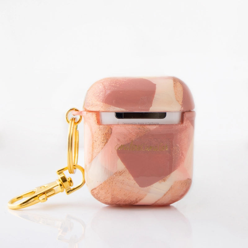 Funda para AirPods Cinnamon Signature Strokes con pinceladas artísticas en tonos cálidos inspiradas en crecimiento, viajes y libertad. Pintada por Ana Tere Canales.