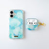 Fundas para proteger iPhone y AirPods, pintadas a mano por Ana Tere Canales. Un diseño con color blanco, aqua y celeste, representando nubes.