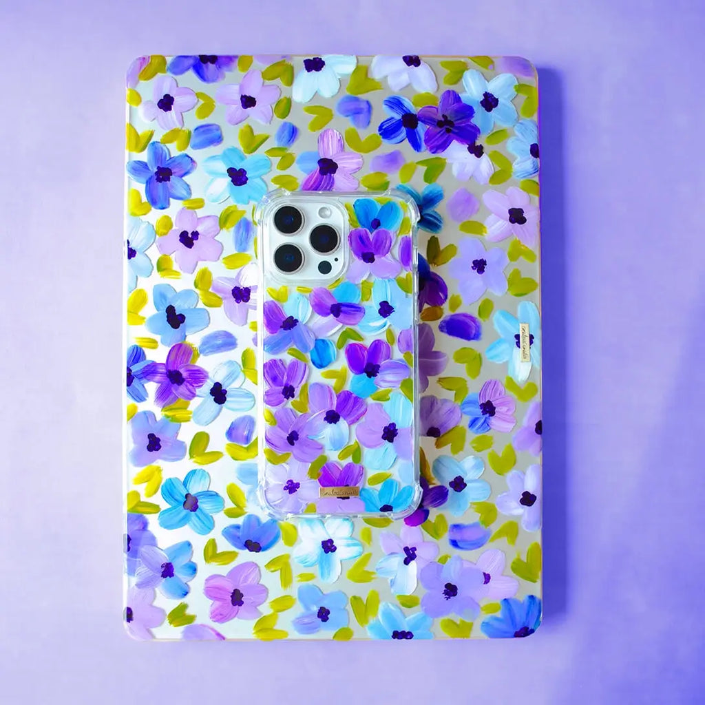 Fundas para proteger iPhone y MacBook, pintadas a mano por Ana Tere Canales. Un diseño de flores en morados y verdes.