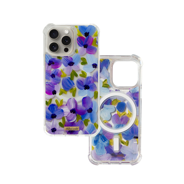Funda MagSafe para proteger iPhone, pintada a mano por Ana Tere Canales. Un diseño de flores en morados y verdes.
