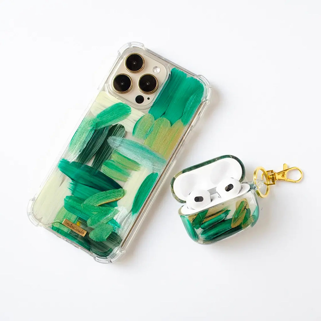 Fundas para proteger iPhone y AirPods, pintadas a mano por Ana Tere Canales. Un diseño en tonos verdes con toques dorados.
