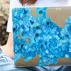 Funda para proteger MacBook, pintada a mano por Ana Tere Canales. Un diseño en tonos azules, representando las olas del mar.