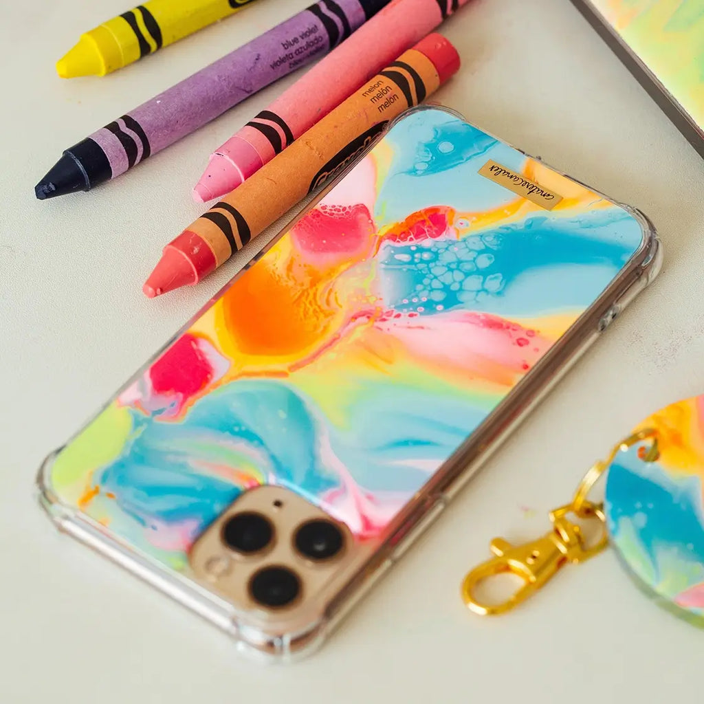 Funda para proteger iPhone y llavero, pintadas a mano por Ana Tere Canales. Un diseño diseño mármol en colores vibrantes.