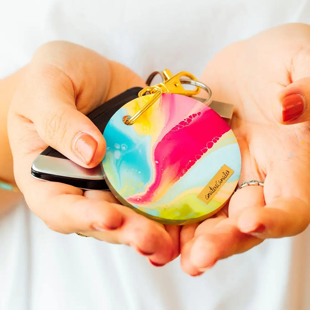 Llavero circular pintado a mano por Ana Tere Canales. Un diseño mármol en colores vibrantes.