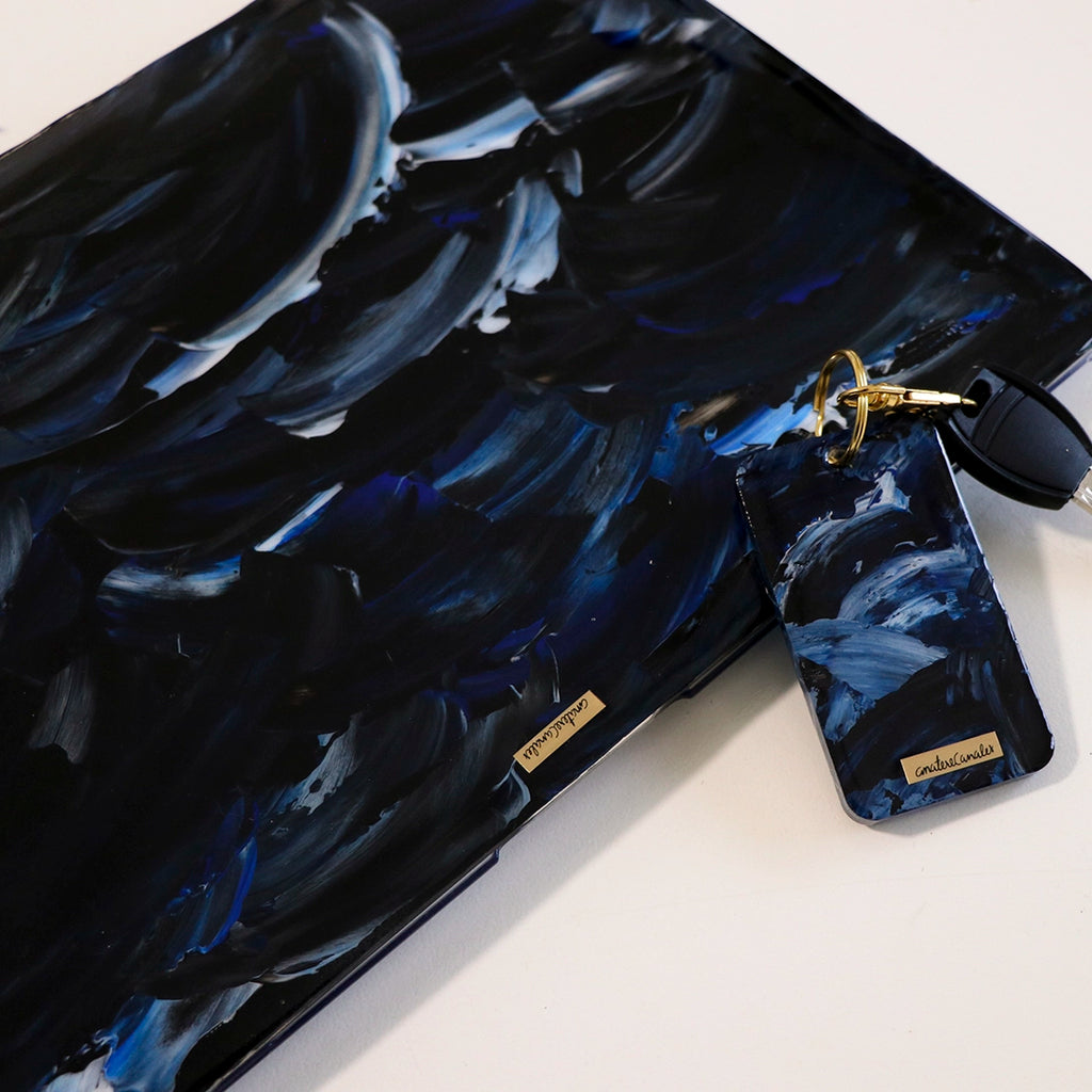 Funda para MacBook y llavero Pacífico pintados a mano por Ana Tere Canales. Un diseño artístico inspirado en el océano en tonos azules.