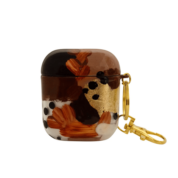 Funda para proteger AirPods, pintada a mano por Ana Tere Canales. Un diseño en tonos tierra con toques dorados.