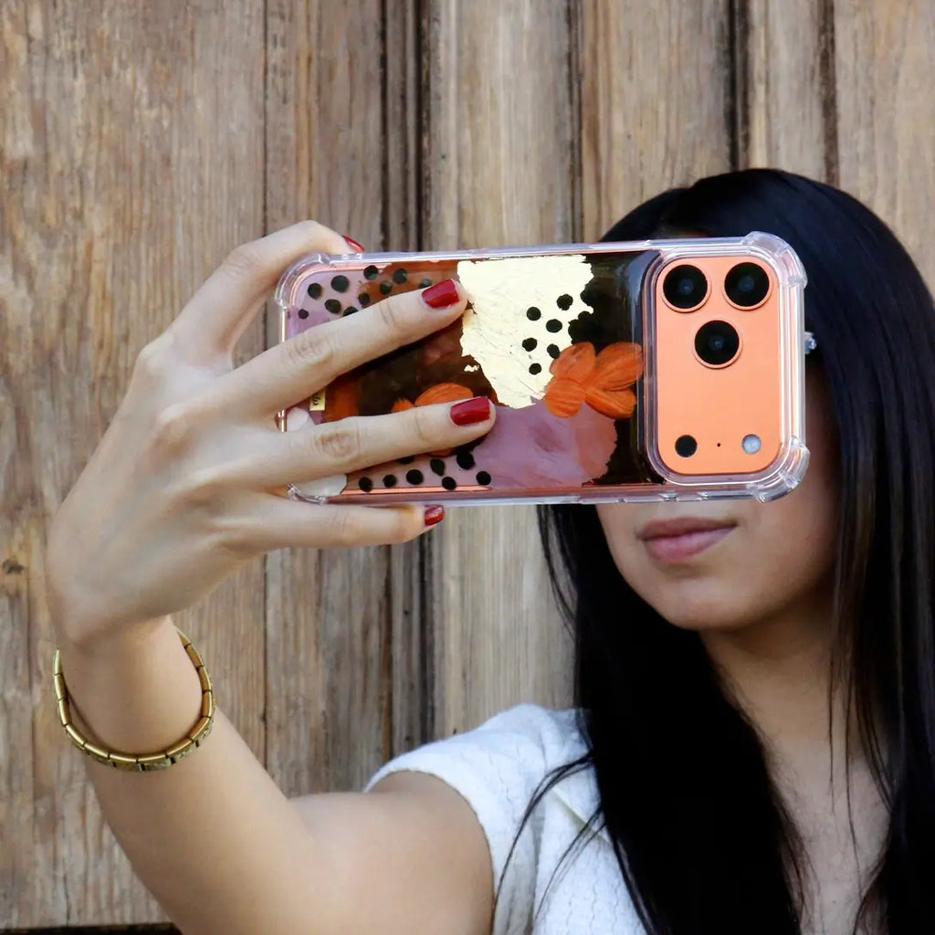 Funda para proteger iPhone, pintada a mano por Ana Tere Canales. Un diseño en tonos tierra con toques dorados.