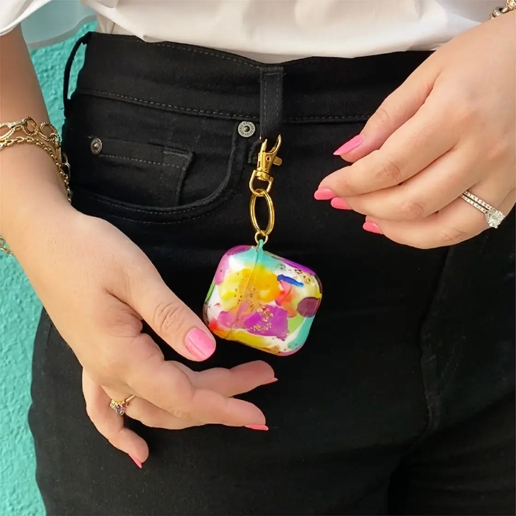 Funda para proteger AirPods pintada a mano por Ana Tere Canales. Con diseño abstracto en colores vibrantes y textura real de pinceladas. Perfecta para dar un estilo creativo y original a tu audífonos.
